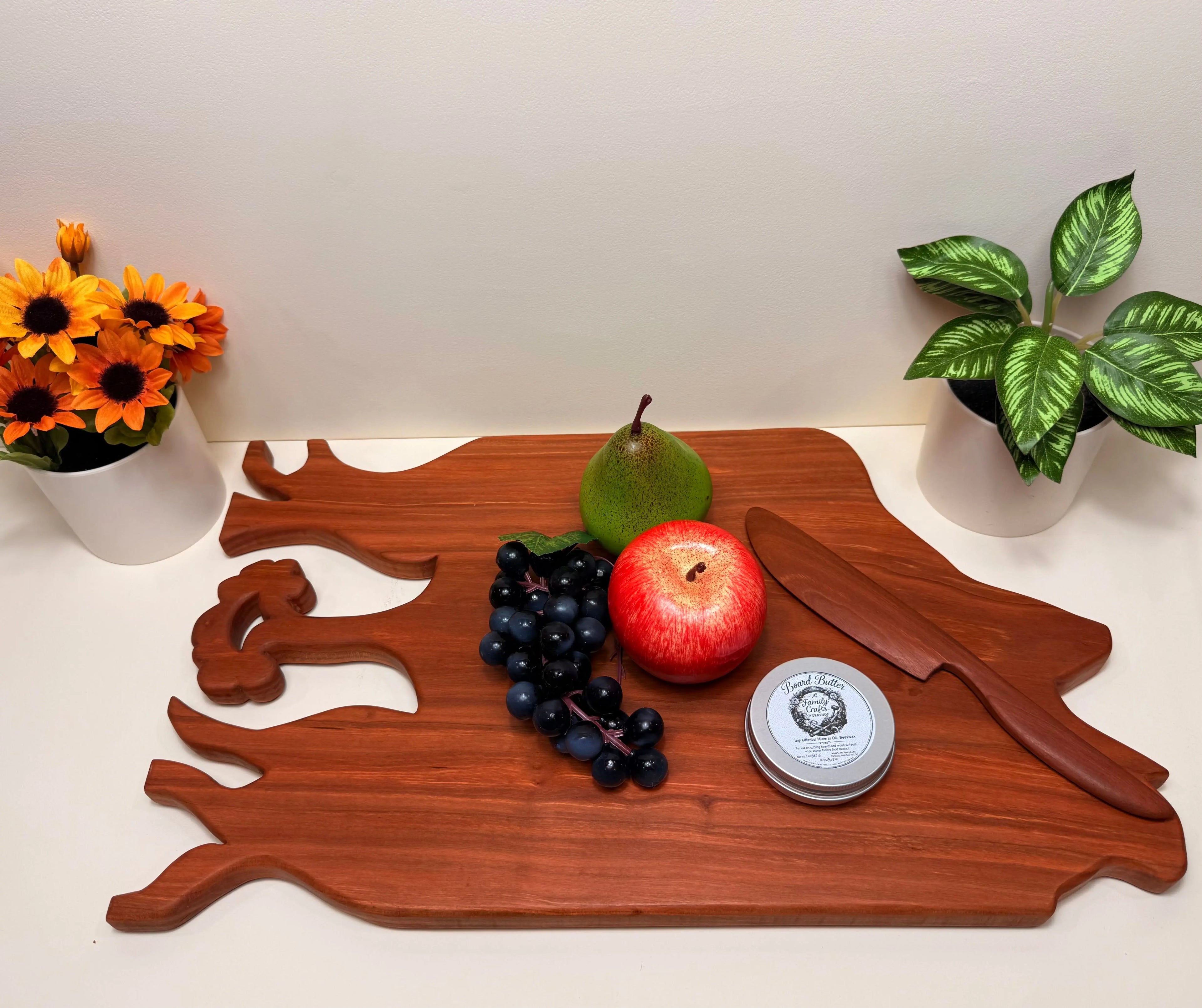 Cherry wood charcuterie board with carved tree motif and cutout handles