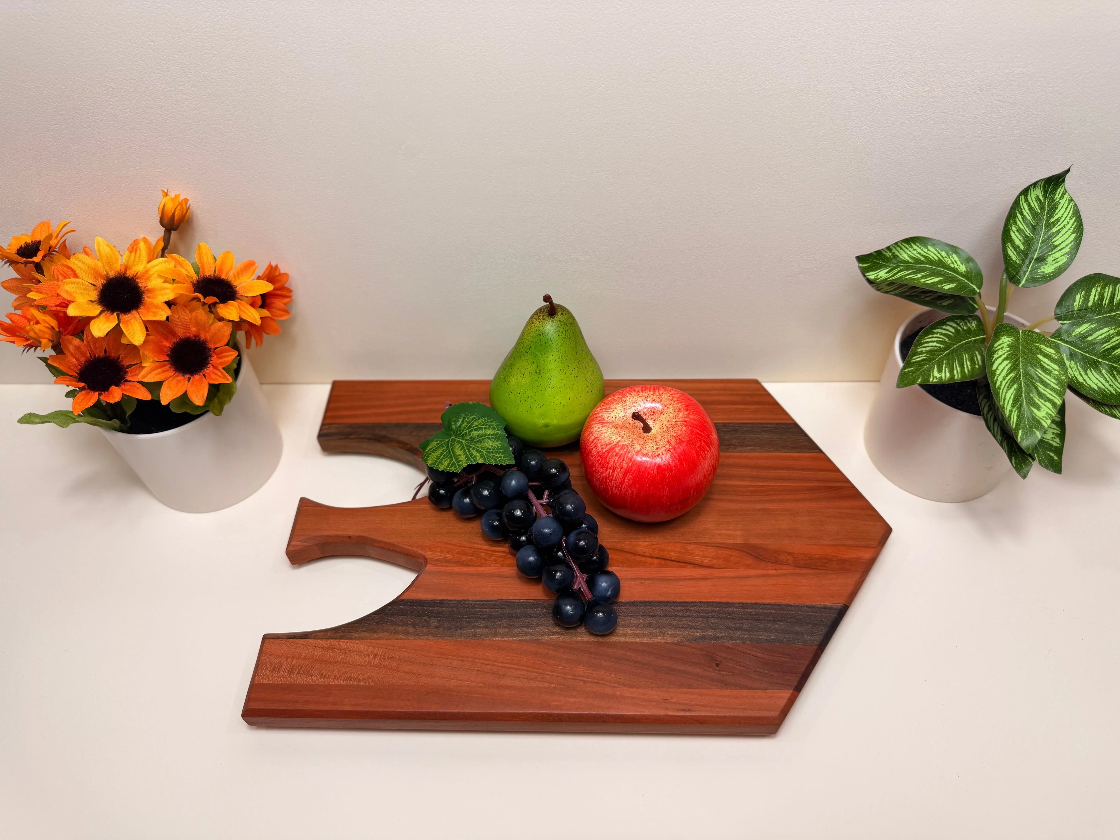 Cherry wood charcuterie serving board with walnut accents and handle grooves, top view