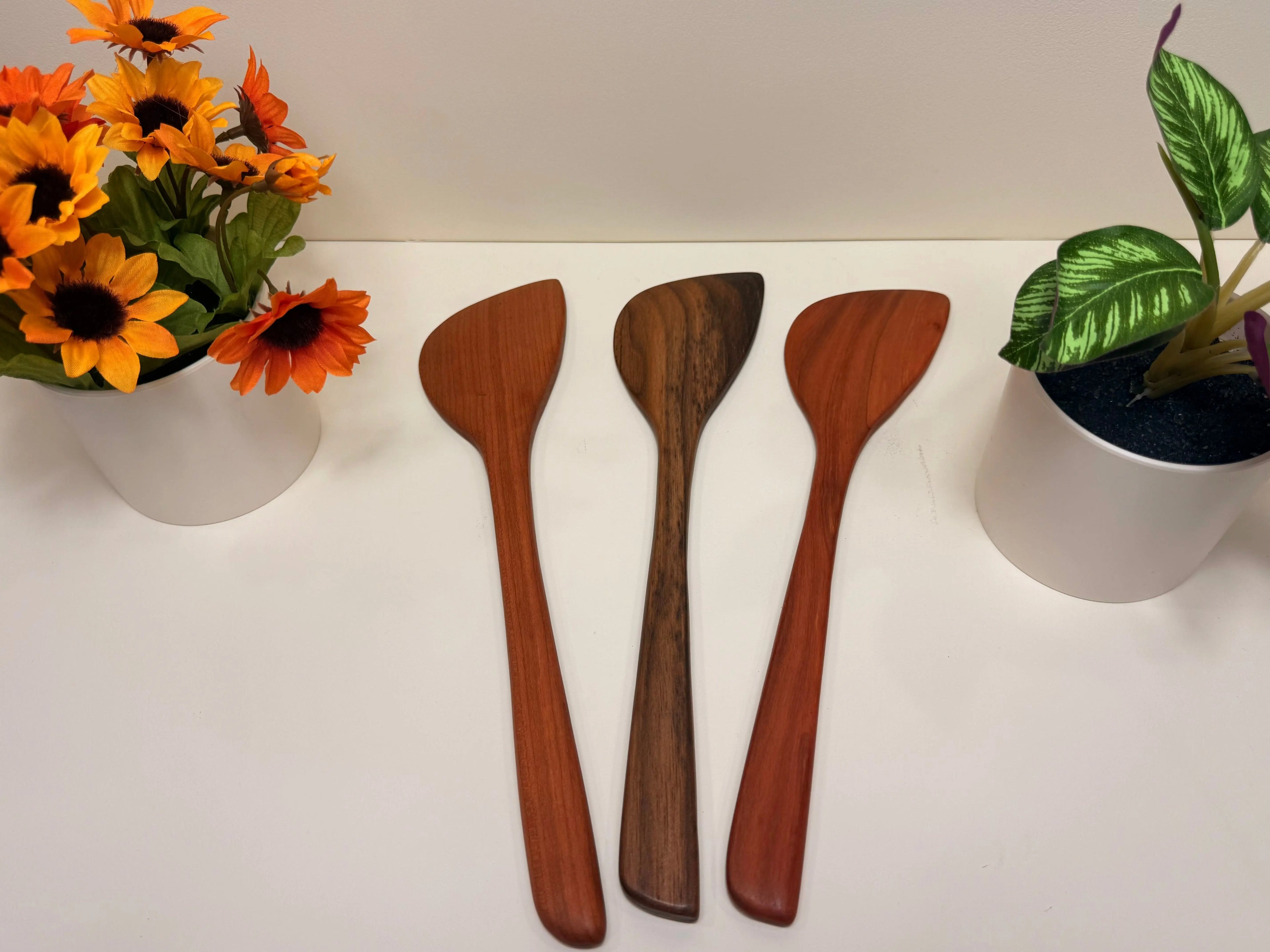 Handcrafted wooden kitchen utensils, three walnut and cherry spoon-spatulas with tapered handles