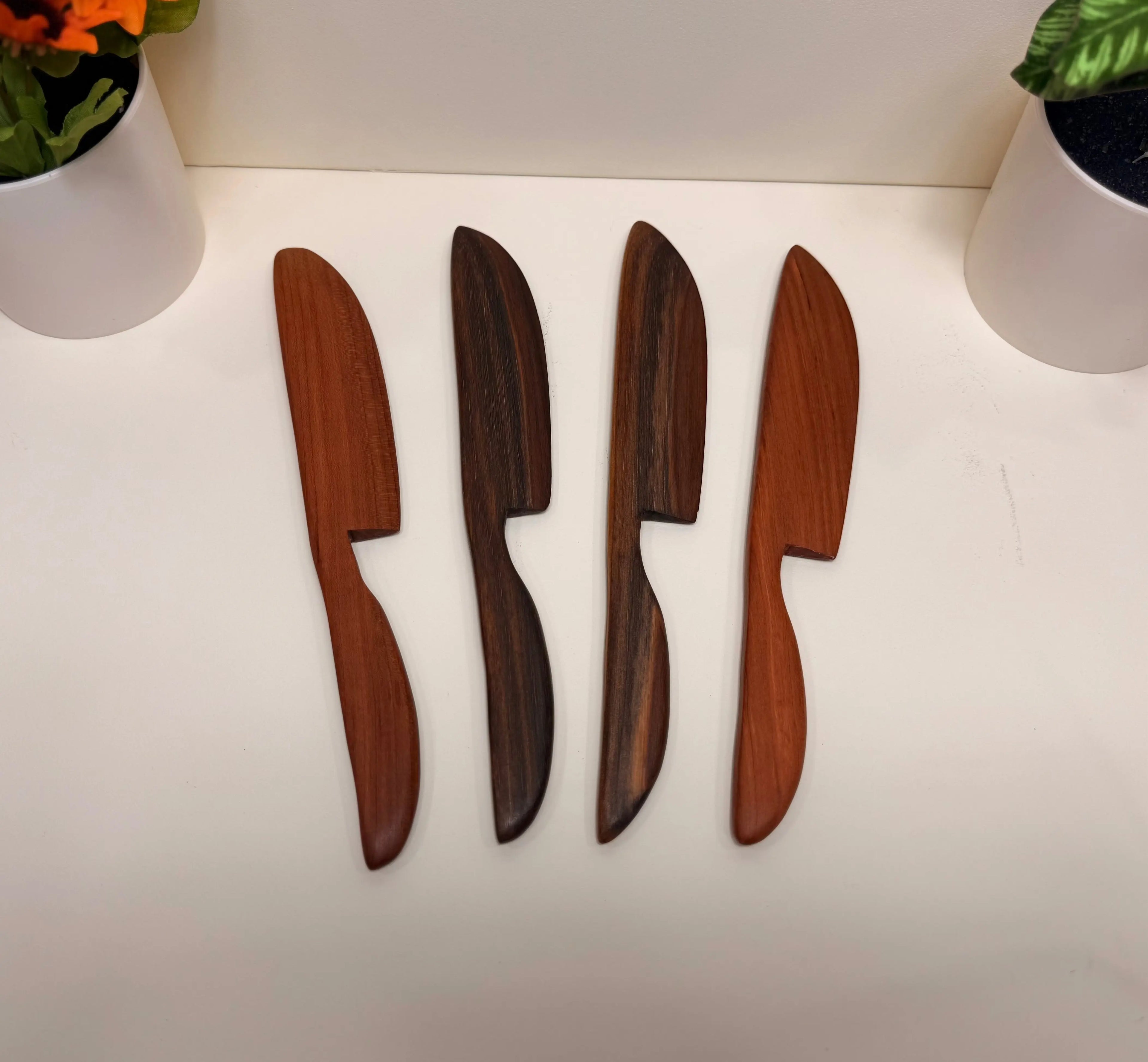 Wooden butter spreaders with tapered handles in cherry and walnut tones