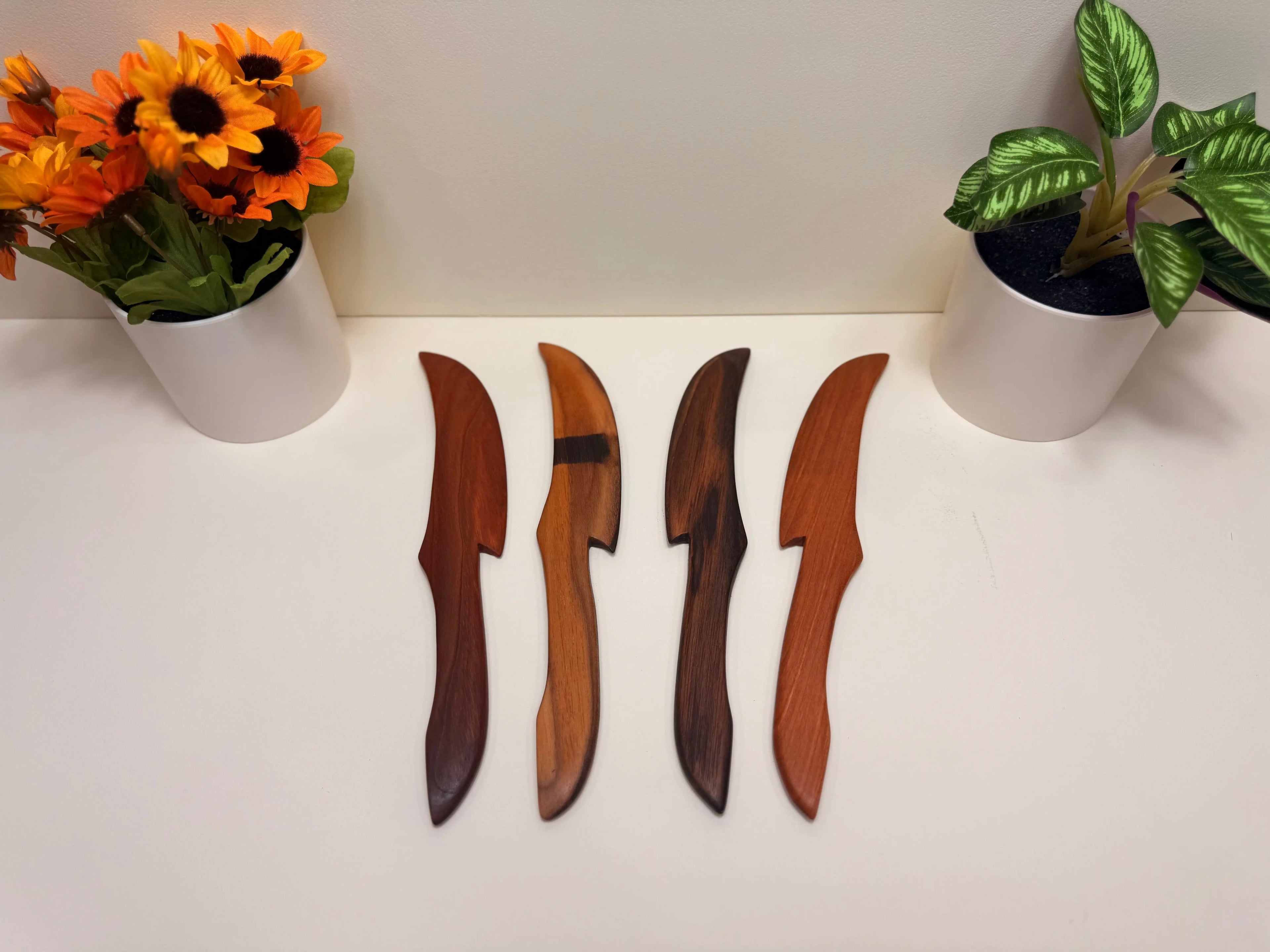 Wood butter spreaders with carved leaf-shaped blades, set of four.