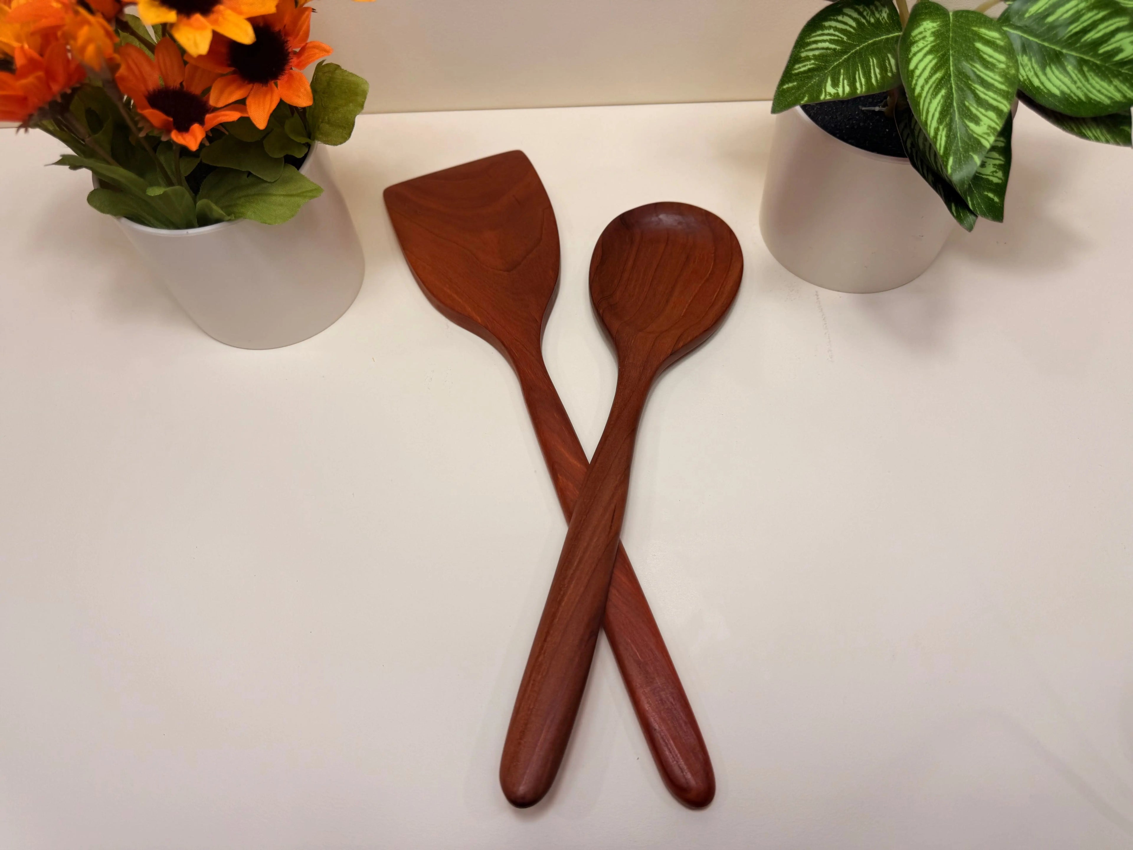 Handcrafted wooden kitchen utensils, two walnut and cherry spoon-spatulas crossed