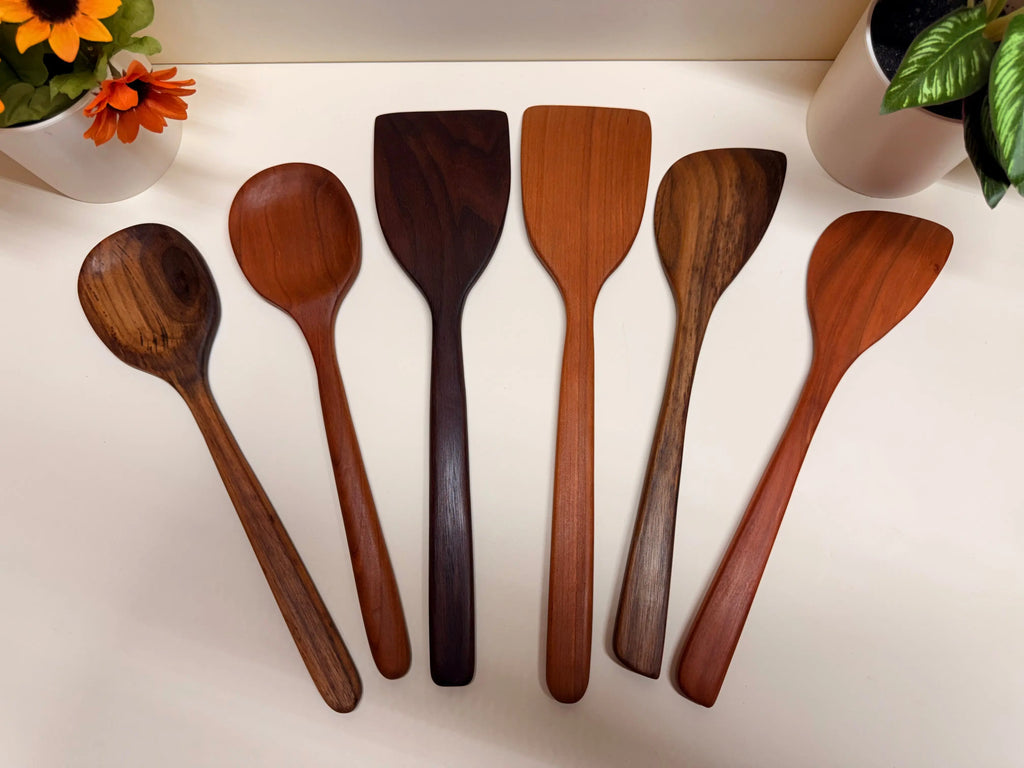 Handcrafted wooden kitchen utensil set in walnut or cherry, varied spoon and spatula heads