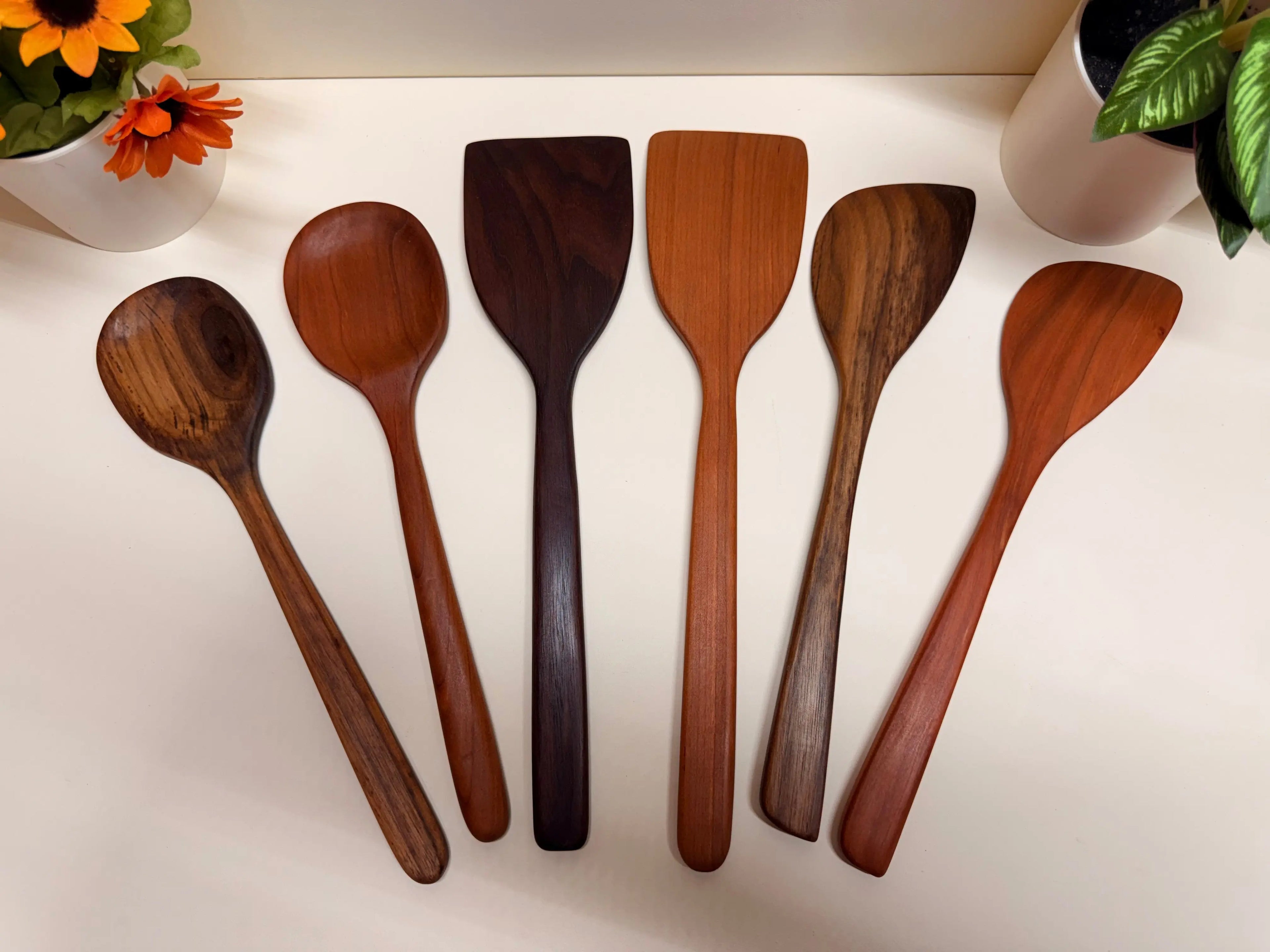 Handcrafted wooden kitchen utensil set in walnut or cherry, varied spoon and spatula heads