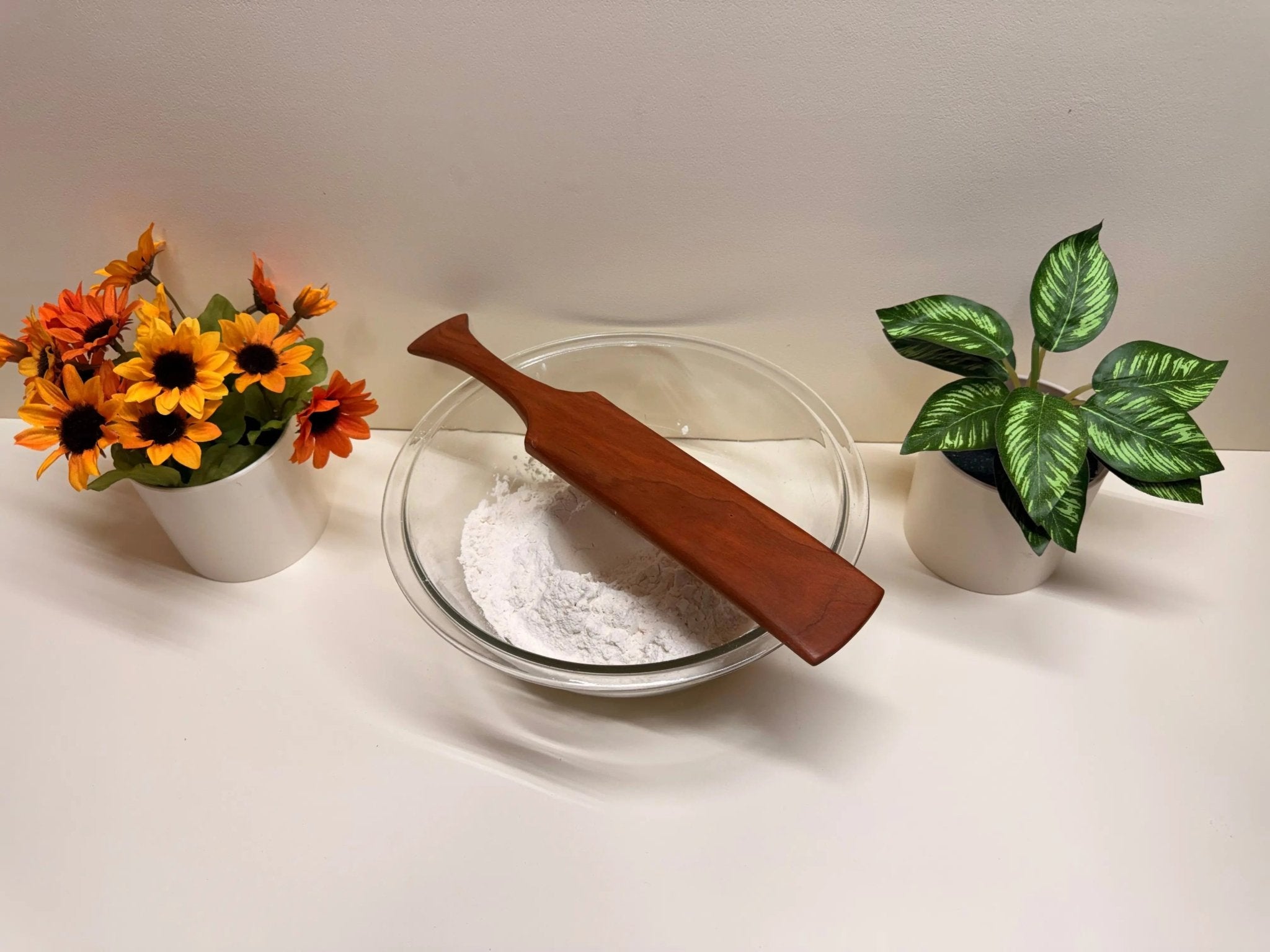 Wood kitchen spurtle in mixing bowl, reddish cherry tone
