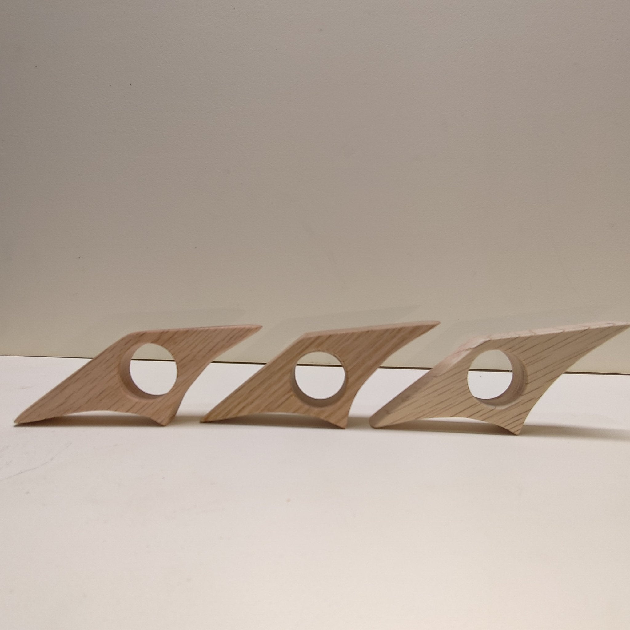 Red oak page holders: three star-shaped clips with round cutouts, spaced on a surface