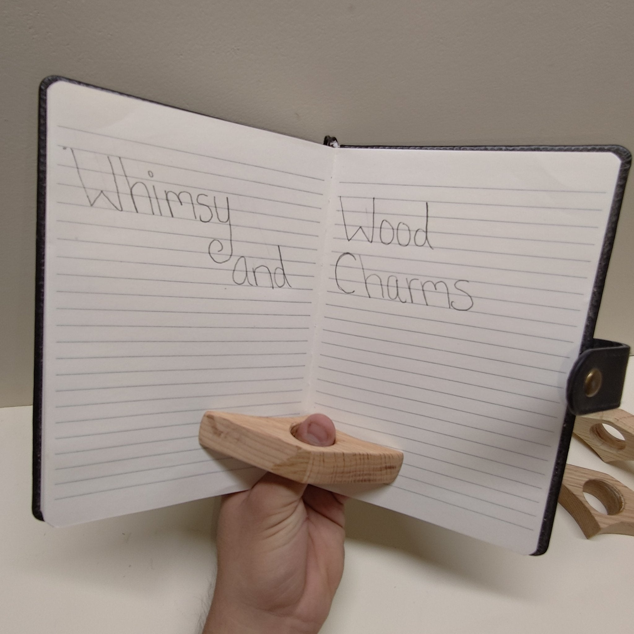 Red oak page holder held in hand: star-shaped light wood with circular cutout