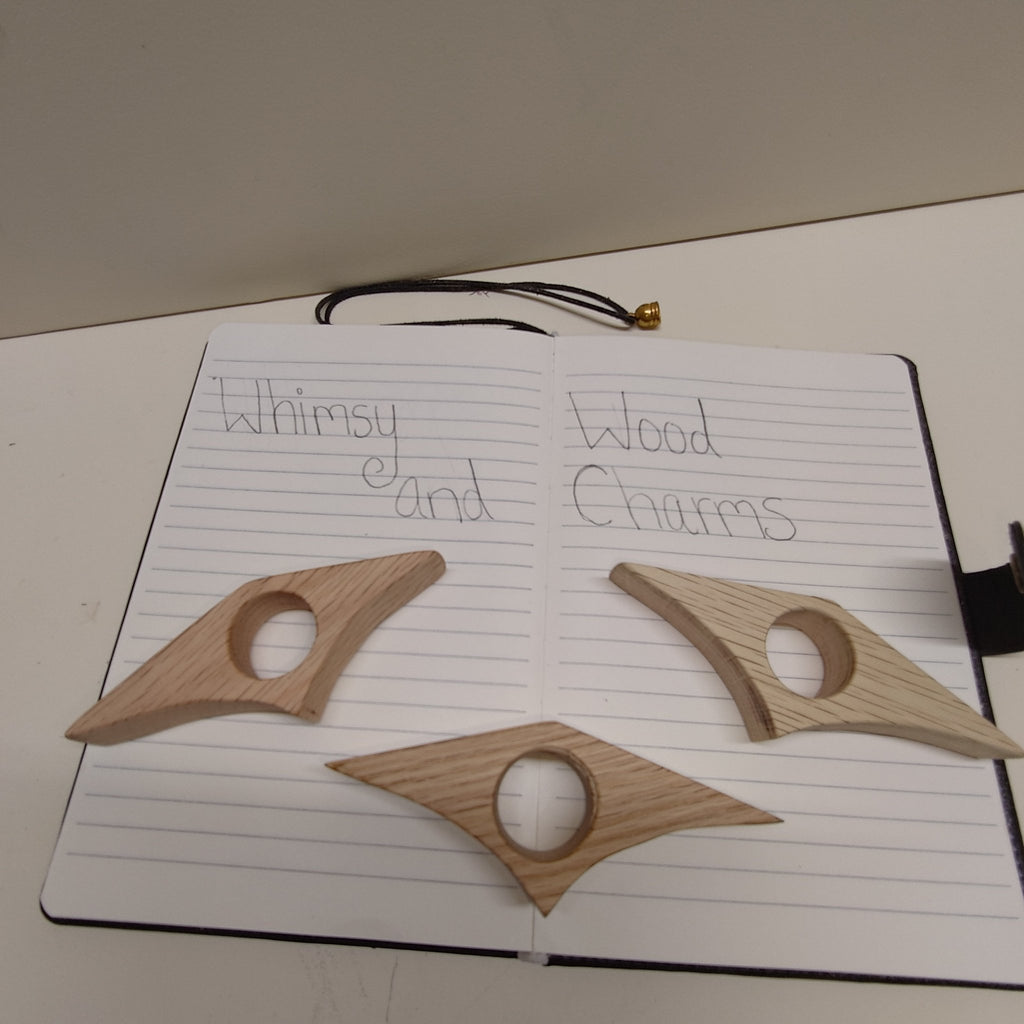 Red oak page holders: two star-shaped wooden clips with circular cutouts on notebook