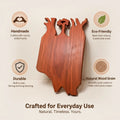 Cherry wood charcuterie board with carved tree motif and cutout handles